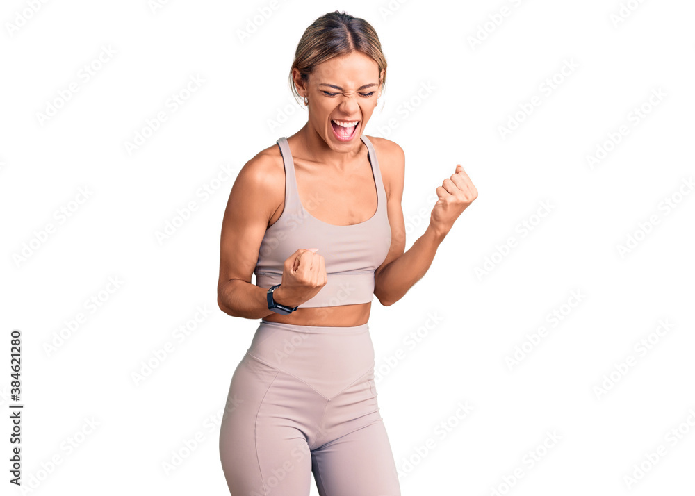 Beautiful caucasian woman wearing sportswear celebrating surprised and amazed for success with arms raised and eyes closed. winner concept. Beautiful caucasian woman wearing sportswear celebrating surprised and amazed for success with arms raised and eyes closed. winner concept.