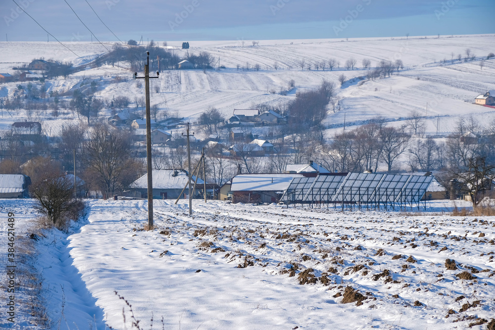 Ukrainian rural landscape with snow on a sunny winter morning. Solar panels in winter. Ukrainian rural landscape with snow on a sunny winter morning. Solar panels in winter.