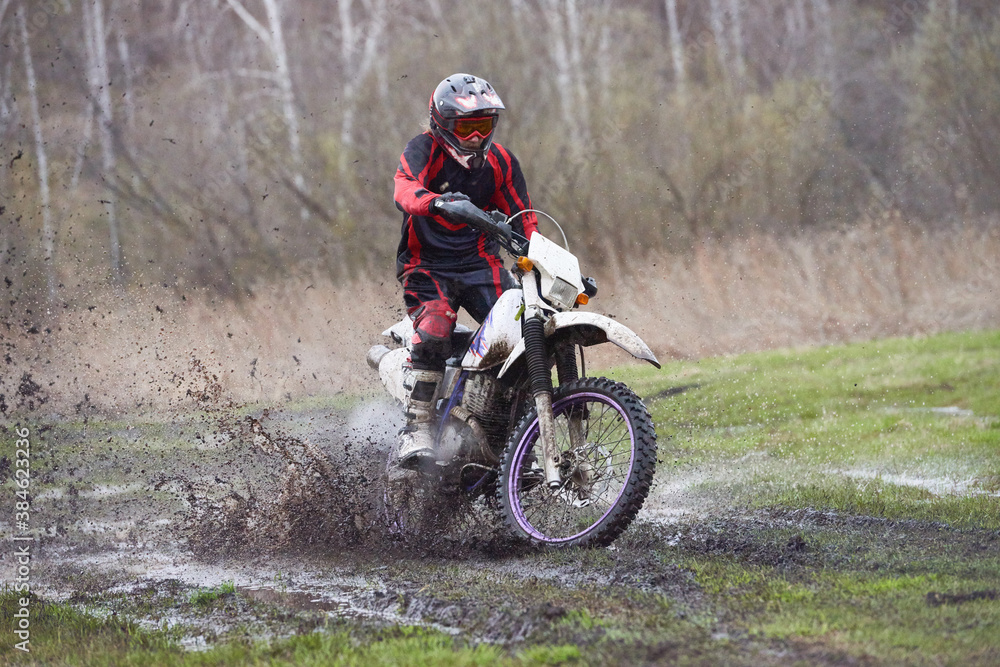 Motorcross rider racing in mud track Motorcross rider racing in mud track