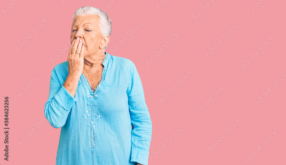 Senior beautiful woman with blue eyes and grey hair wearing summer dress bored yawning tired covering mouth with hand. restless and sleepiness. Senior beautiful woman with blue eyes and grey hair wearing summer dress bored yawning tired covering mouth with hand. restless and sleepiness.
