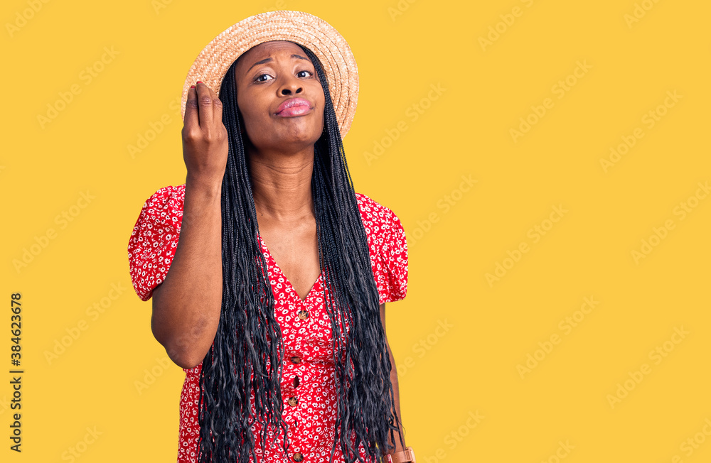 Young african american woman wearing summer hat doing italian gesture with hand and fingers confident expression Young african american woman wearing summer hat doing italian gesture with hand and fingers confident expression