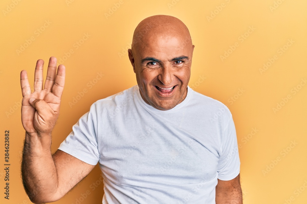 Mature middle east man wearing casual white tshirt showing and pointing up with fingers number four while smiling confident and happy. Mature middle east man wearing casual white tshirt showing and pointing up with fingers number four while smiling confident and happy.