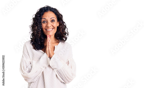 Middle age beautiful woman wearing casual sweater praying with hands together asking for forgiveness smiling confident. © Krakenimages.com