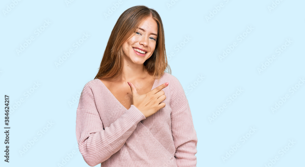 Beautiful blonde woman wearing casual winter pink sweater cheerful with a smile on face pointing with hand and finger up to the side with happy and natural expression Beautiful blonde woman wearing casual winter pink sweater cheerful with a smile on face pointing with hand and finger up to the side with happy and natural expression