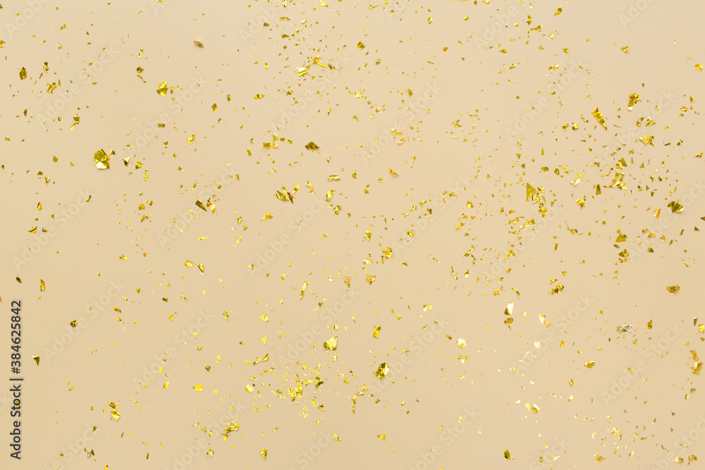 Golden confetti on beige paper trendy background. Festive holiday backdrop. Birthday congratulations Christmas New Year. Flat lay, top view, copy space. Golden confetti on beige paper trendy background. Festive holiday backdrop. Birthday congratulations Christmas New Year. Flat lay, top view, copy space.