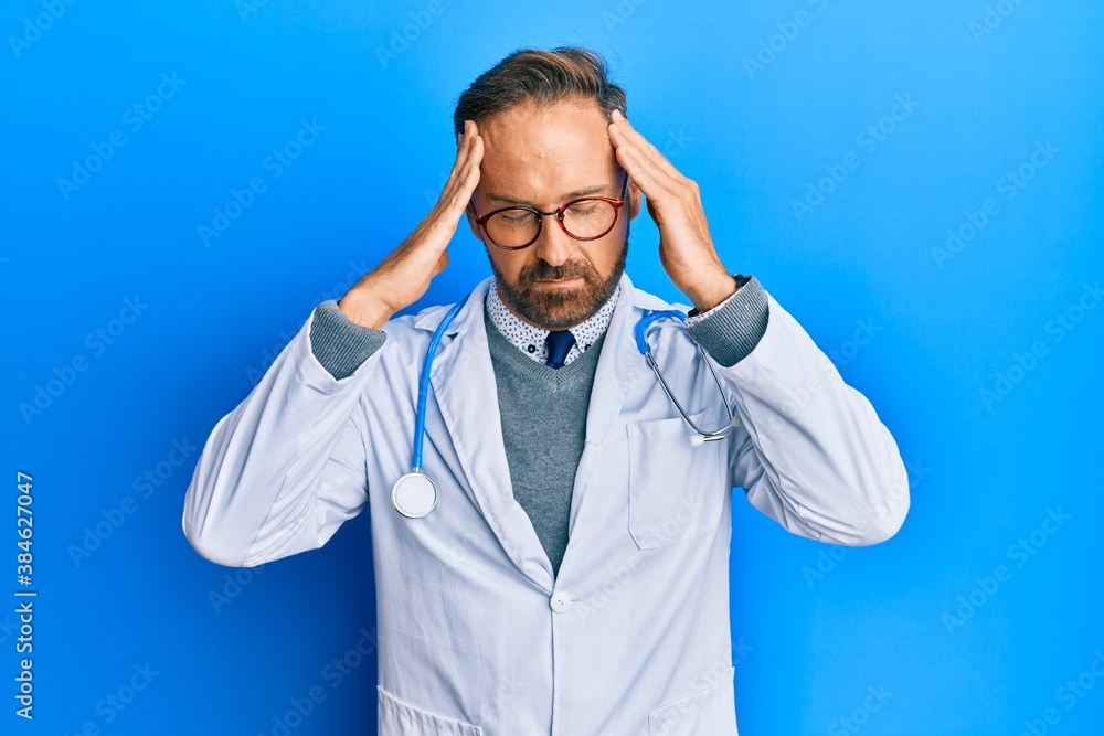 Handsome middle age man wearing doctor uniform and stethoscope with hand on head for pain in head because stress. suffering migraine. Handsome middle age man wearing doctor uniform and stethoscope with hand on head for pain in head because stress. suffering migraine.