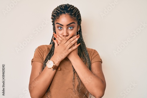 Young african american woman with braids wearing casual clothes shocked covering mouth with hands for mistake. secret concept.