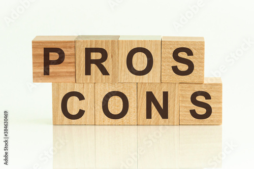 Pros Cons - text on wooden cubes on a white gradient background.