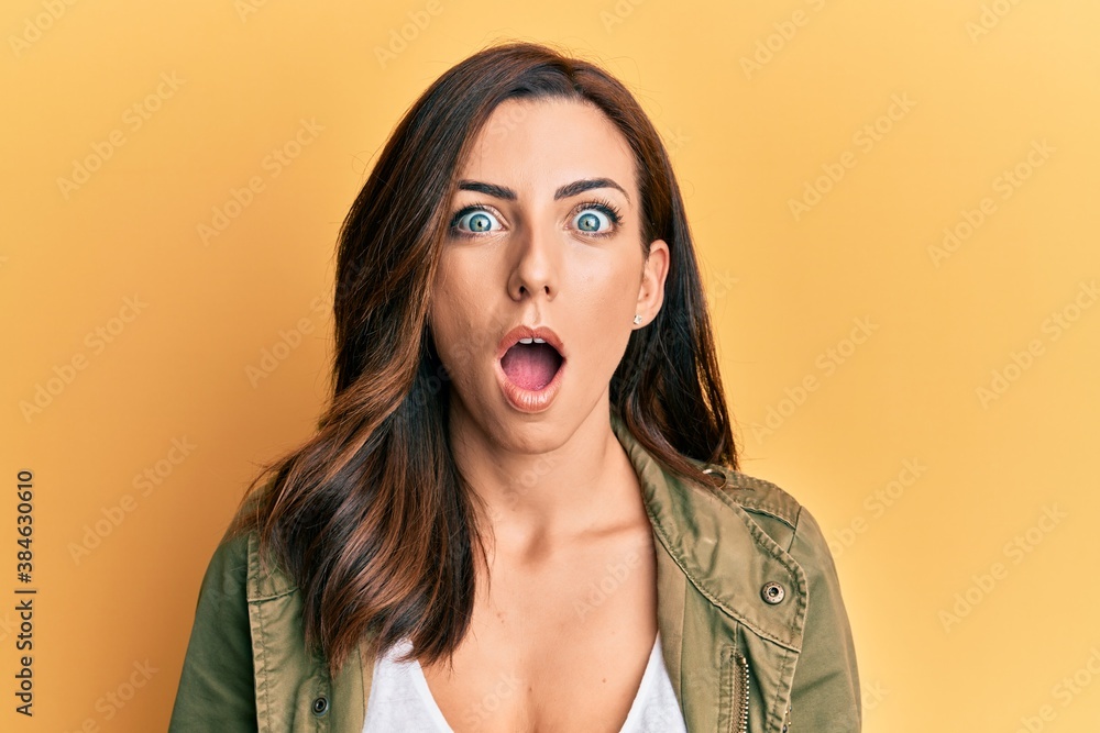 Young brunette woman wearing casual clothes over yellow background afraid and shocked with surprise and amazed expression, fear and excited face. Young brunette woman wearing casual clothes over yellow background afraid and shocked with surprise and amazed expression, fear and excited face.
