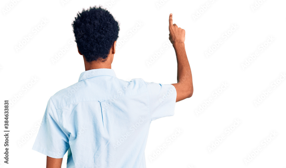 Young african american man wearing casual clothes posing backwards pointing ahead with finger hand Young african american man wearing casual clothes posing backwards pointing ahead with finger hand