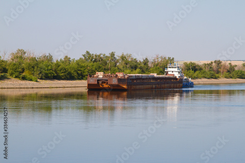 Photo Cargo ship moving along the river