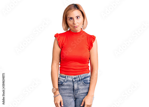 Young blonde woman wearing casual clothes making fish face with lips, crazy and comical gesture. funny expression. © Krakenimages.com