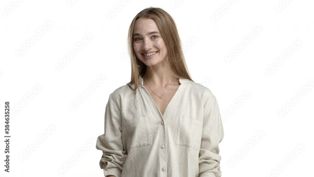 Happy adult woman with long fair hair, wearing beige blouse and necklace, saying yes and nodding in approval, agree with someone, smiling satisfied and standing over white background Happy adult woman with long fair hair, wearing beige blouse and necklace, saying yes and nodding in approval, agree with someone, smiling satisfied and standing over white background