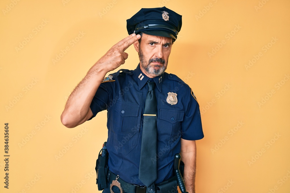 Middle age hispanic man wearing police uniform shooting and killing oneself pointing hand and fingers to head like gun, suicide gesture. Middle age hispanic man wearing police uniform shooting and killing oneself pointing hand and fingers to head like gun, suicide gesture.