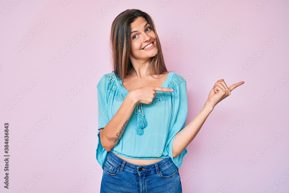 Beautiful caucasian woman wearing casual clothes smiling and looking at the camera pointing with two hands and fingers to the side. Beautiful caucasian woman wearing casual clothes smiling and looking at the camera pointing with two hands and fingers to the side.
