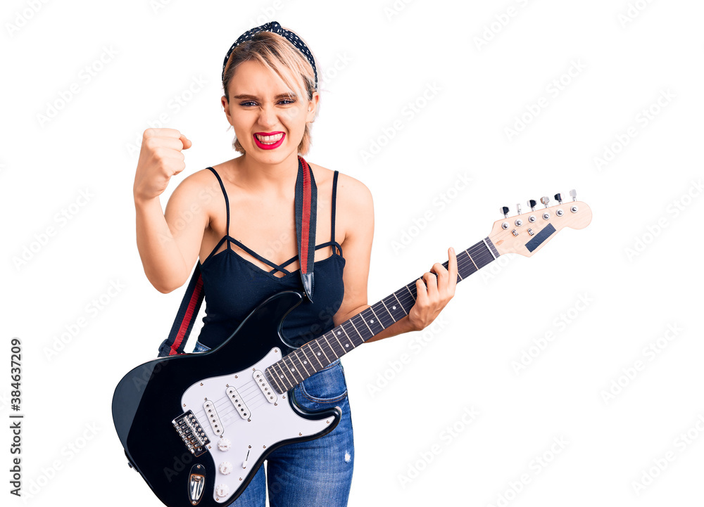 Young beautiful blonde woman playing electric guitar annoyed and frustrated shouting with anger, yelling crazy with anger and hand raised Young beautiful blonde woman playing electric guitar annoyed and frustrated shouting with anger, yelling crazy with anger and hand raised
