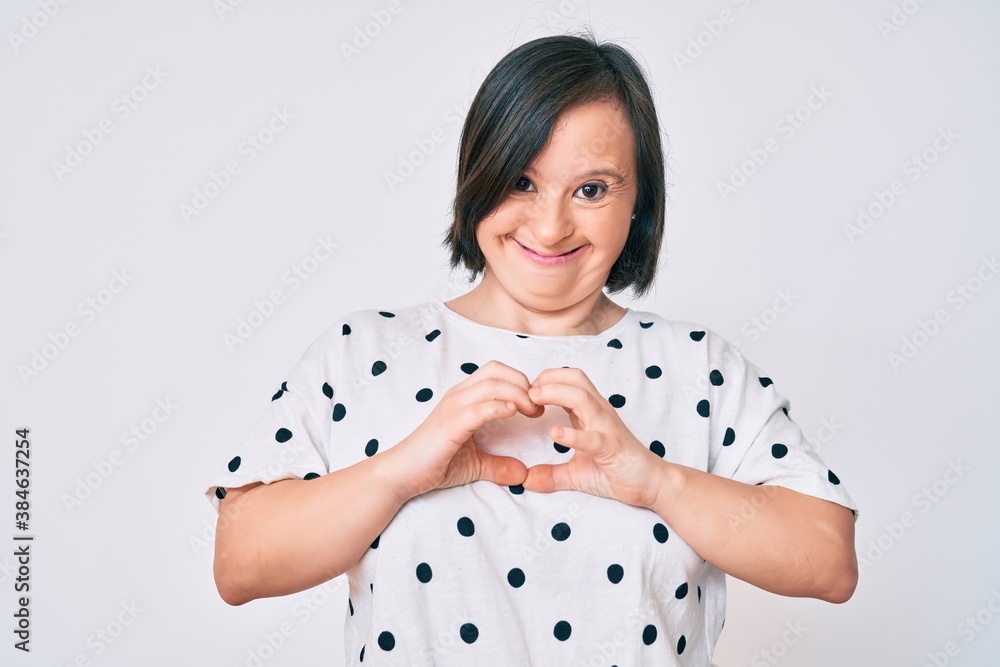 Brunette woman with down syndrome wearing casual clothes smiling in love showing heart symbol and shape with hands. romantic concept. Brunette woman with down syndrome wearing casual clothes smiling in love showing heart symbol and shape with hands. romantic concept.