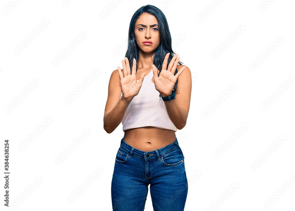 Beautiful hispanic woman wearing casual clothes moving away hands palms showing refusal and denial with afraid and disgusting expression. stop and forbidden. Beautiful hispanic woman wearing casual clothes moving away hands palms showing refusal and denial with afraid and disgusting expression. stop and forbidden.