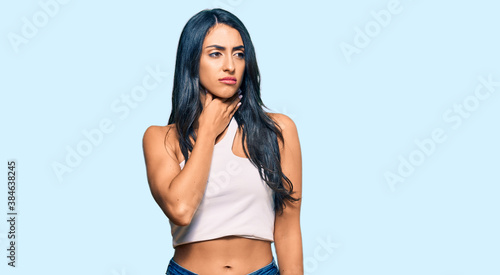 Beautiful hispanic woman wearing casual clothes touching painful neck, sore throat for flu, clod and infection