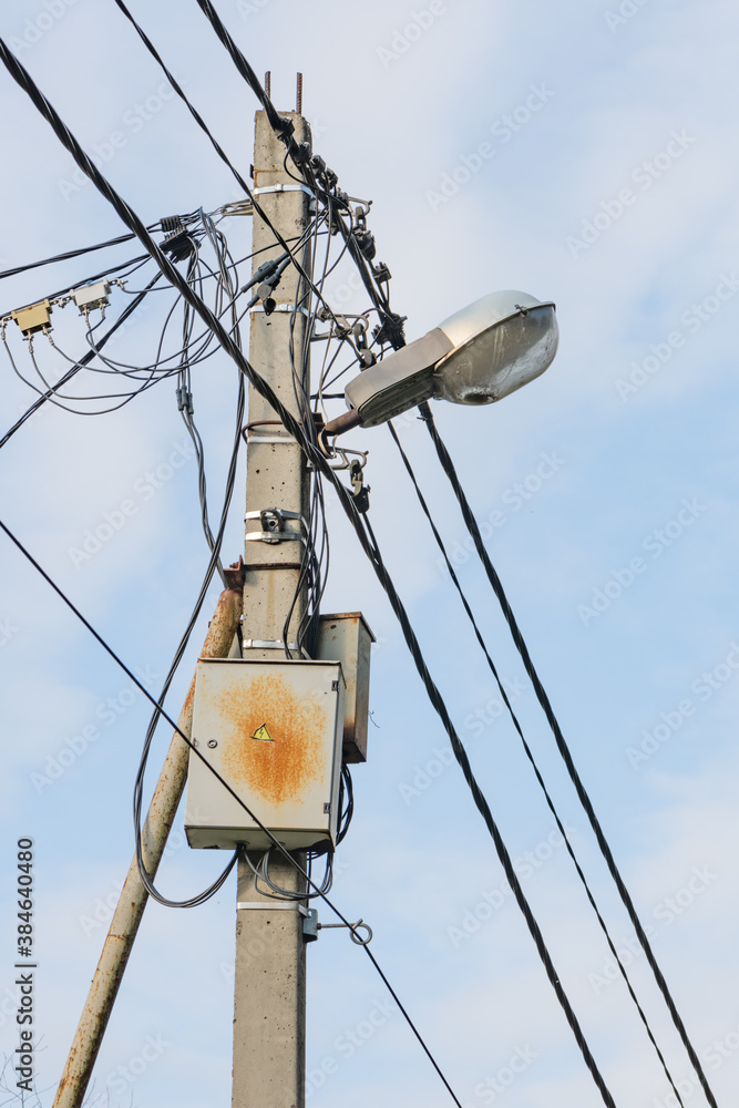 Concrete pole with outdoor street light and electricity wires. Concrete pole with outdoor street light and electricity wires.