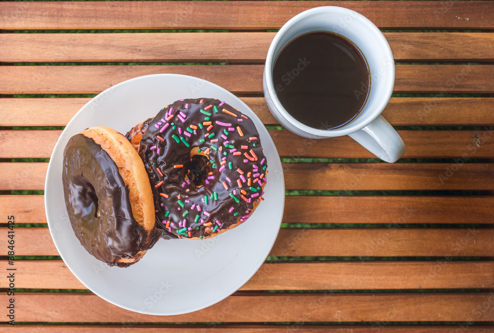 Sweet Donuts piled up beside a cup of coffee on a flat layout image Sweet Donuts piled up beside a cup of coffee on a flat layout image