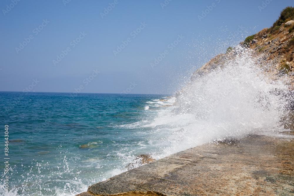 Sea water beats against rocky rocks and makes waves with foam Sea water beats against rocky rocks and makes waves with foam