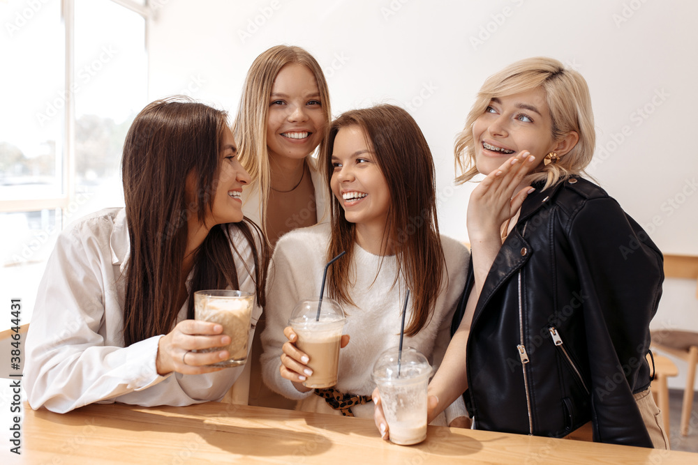 Happy four young women friends having coffee break while relaxing at the cafe indoors. Happy four young women friends having coffee break while relaxing at the cafe indoors.