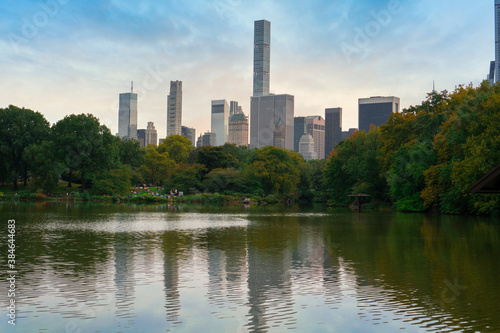 Reflection in lake water of Central Park with a view of trees and skyscrapers in the background