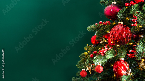 Decorated with ornaments and lights Christmas tree on green background. Merry Christmas and Happy Holidays greeting card  frame  banner. New Year. Noel  
