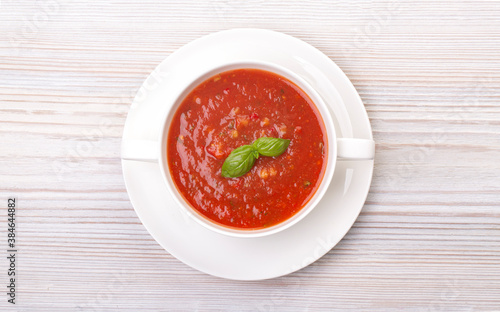 Gazpacho in a white plate and basil