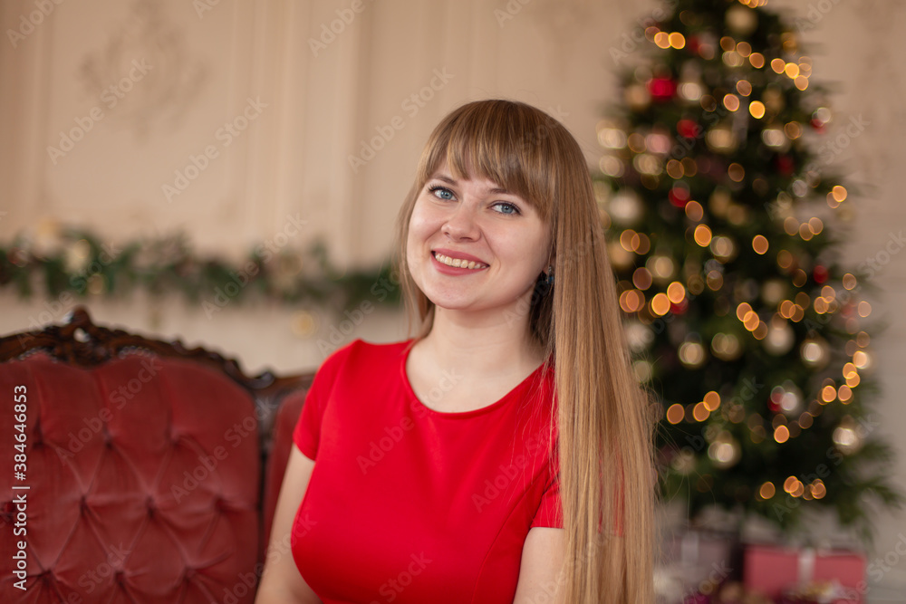 Portrait of a beautiful smiling blonde girl near the Christmas tree Portrait of a beautiful smiling blonde girl near the Christmas tree