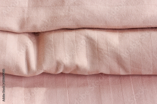 Bed linen on the bed in the room Home textiles as part of the interior Pink satin sheets.