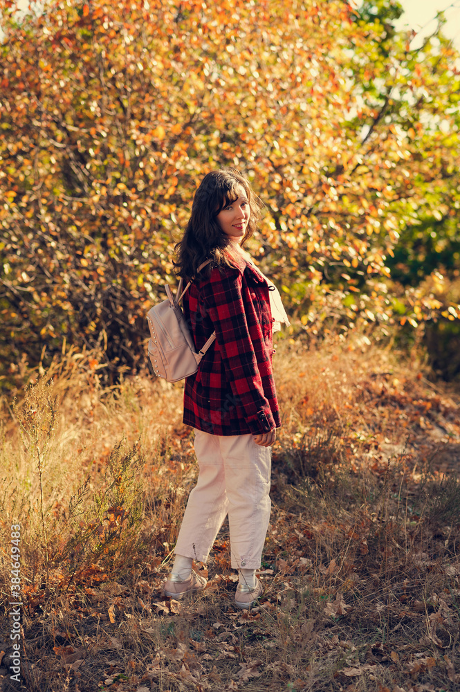 a smiling girl walking through the autumn forest turns around a smiling girl walking through the autumn forest turns around