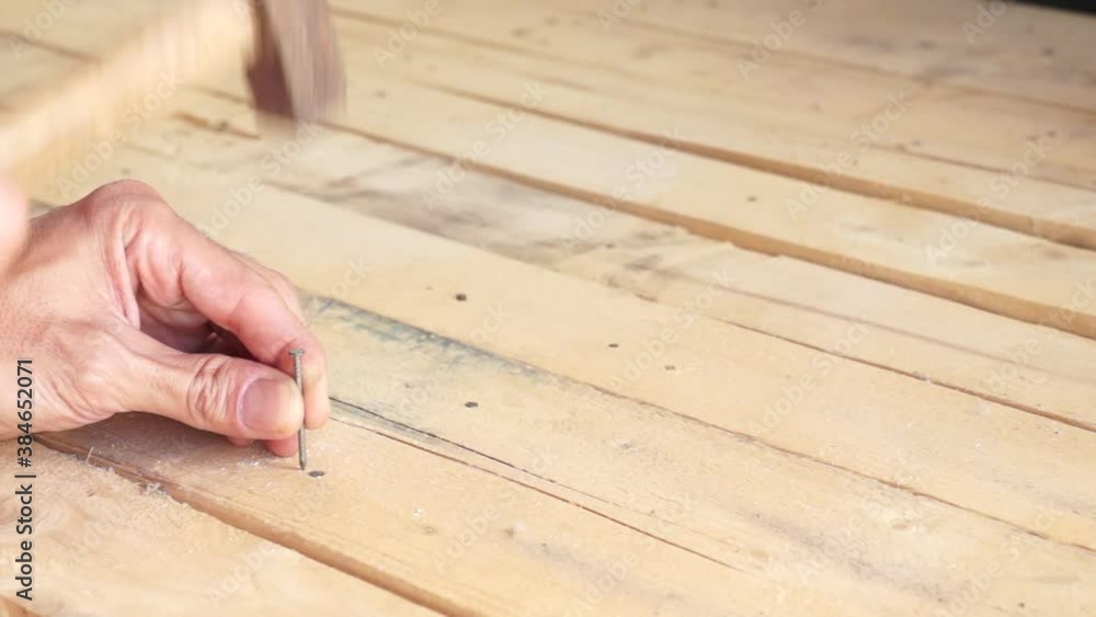 hands driving a nail with a hammer hands driving a nail with a hammer