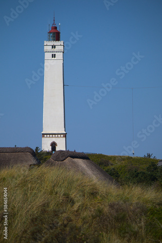 Leuchtturm an der Küste von Blavand Strand vor blauem Himmel