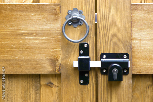 Tanalised double wooden gates ring latch handle and locking bolt closeup
