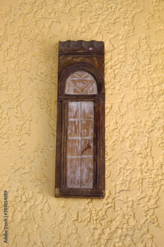 Wood carving on a yellow wall