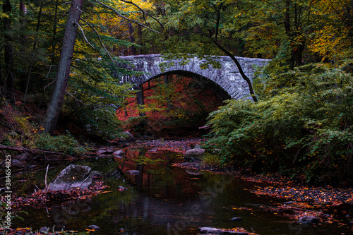 Stone bridge in Rockefeller State Park over the Pocantico River in autumn