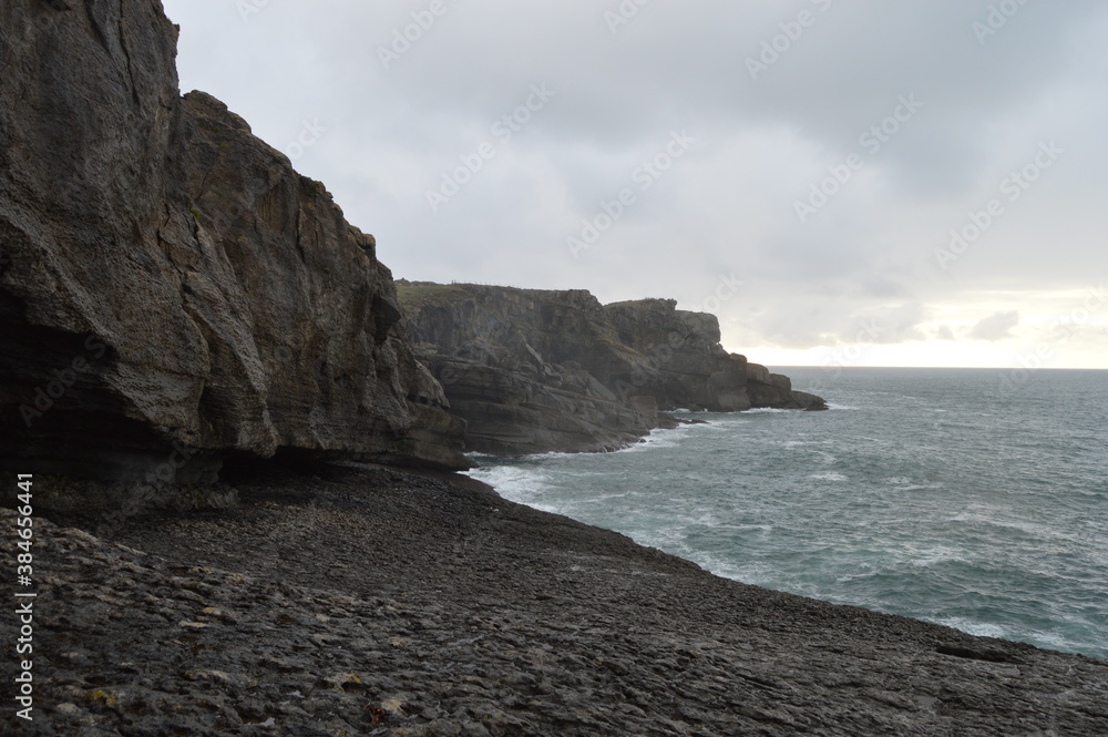 Oceanic huge rocky cliffs with a cloudy sky
