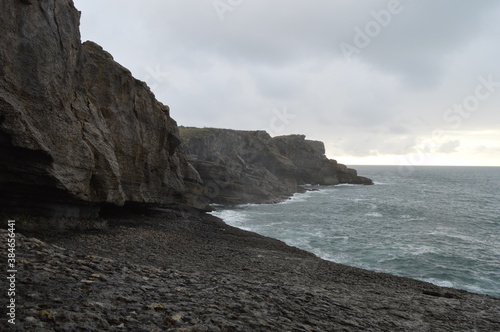Oceanic huge rocky cliffs with a cloudy sky