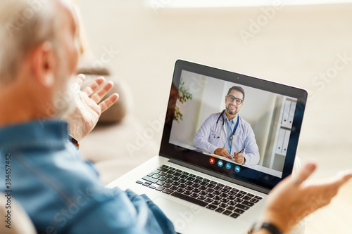 Foto Senior man speaking with online doctor.