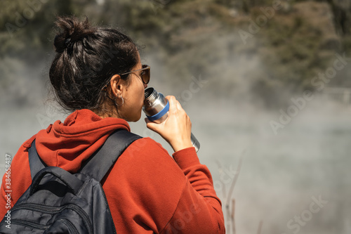 Woman drinking water while touring in hot pools at Kuirau Park. Rotorua, New Zealand photo