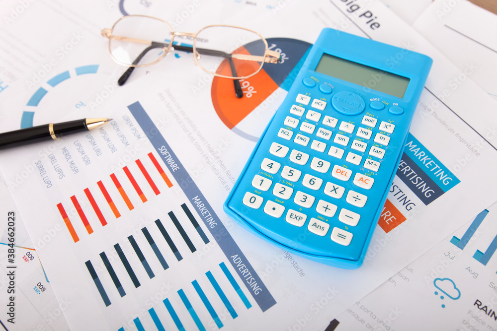 Calculator and signature pen and a pair of glasses on financial documents Calculator and signature pen and a pair of glasses on financial documents