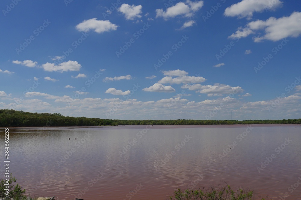 Wide view of the reddish water of Lake Thunderbird in Oklahoma
