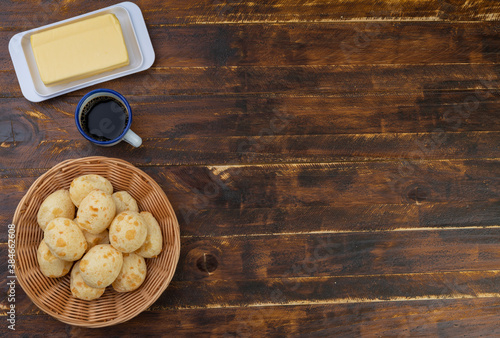 Typical brazilian cheese buns in a basket, butter and coffee with copu space photo