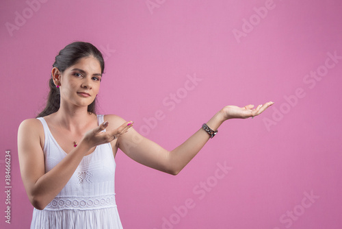 Mujer en viendo al frente con manos extendidas con fondo rosado cáncer de mama photo