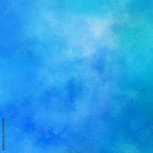 abstract watercolor background painting in blue cloudy colors with painted watercolor wash texture on paper