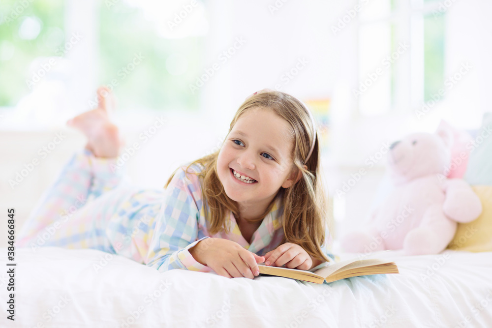 Child reading book in bed. Kids read in bedroom. Child reading book in bed. Kids read in bedroom.