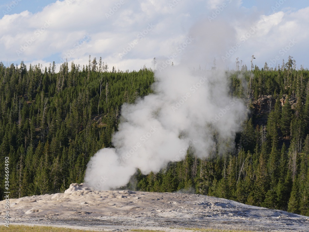 Billows of steam and hot water spurts out of Old Faithful Geyser during ...