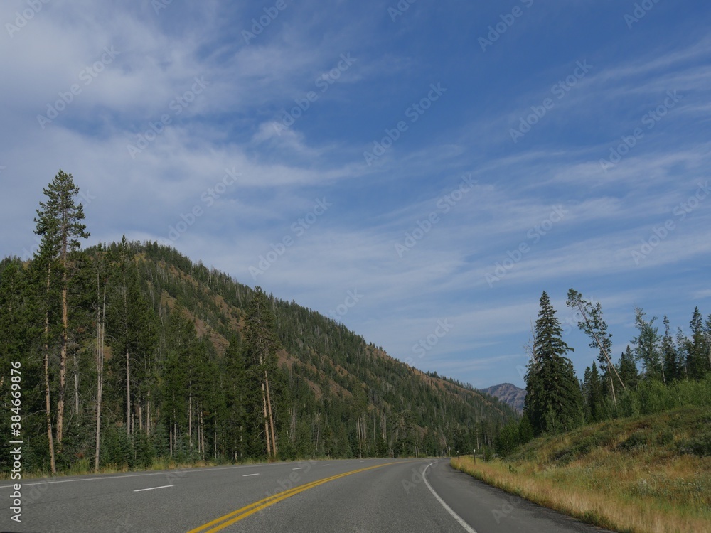 Naklejka premium Scenic winding road along North Fork Highway heading to the east entrance of Yellowstone National Park.